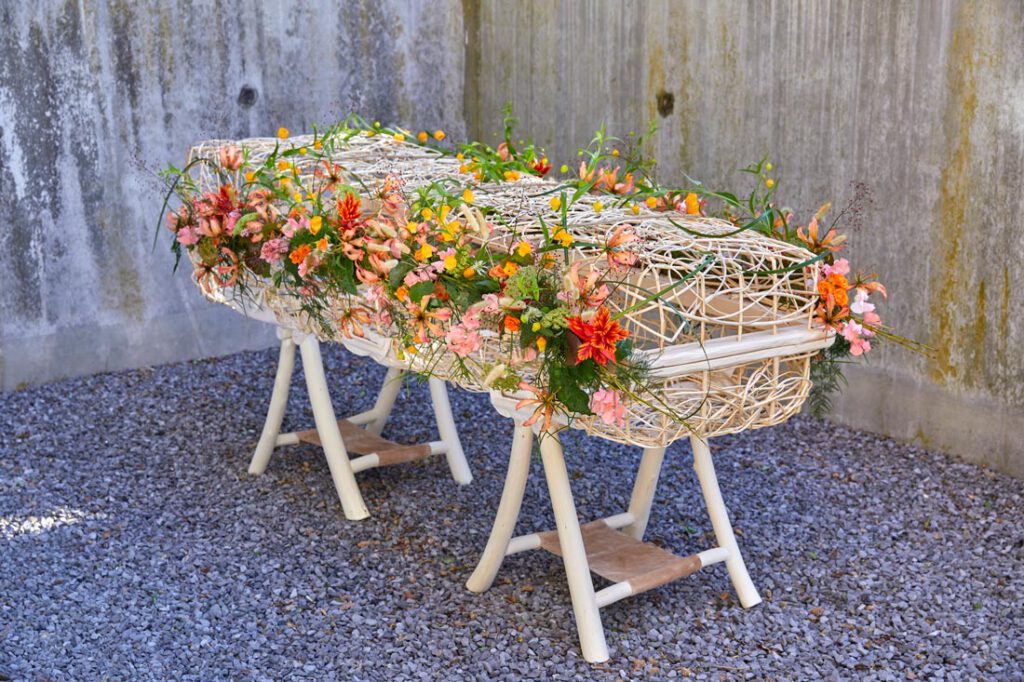 Wilgenmand met bloemen als alternatief voor een houten kist